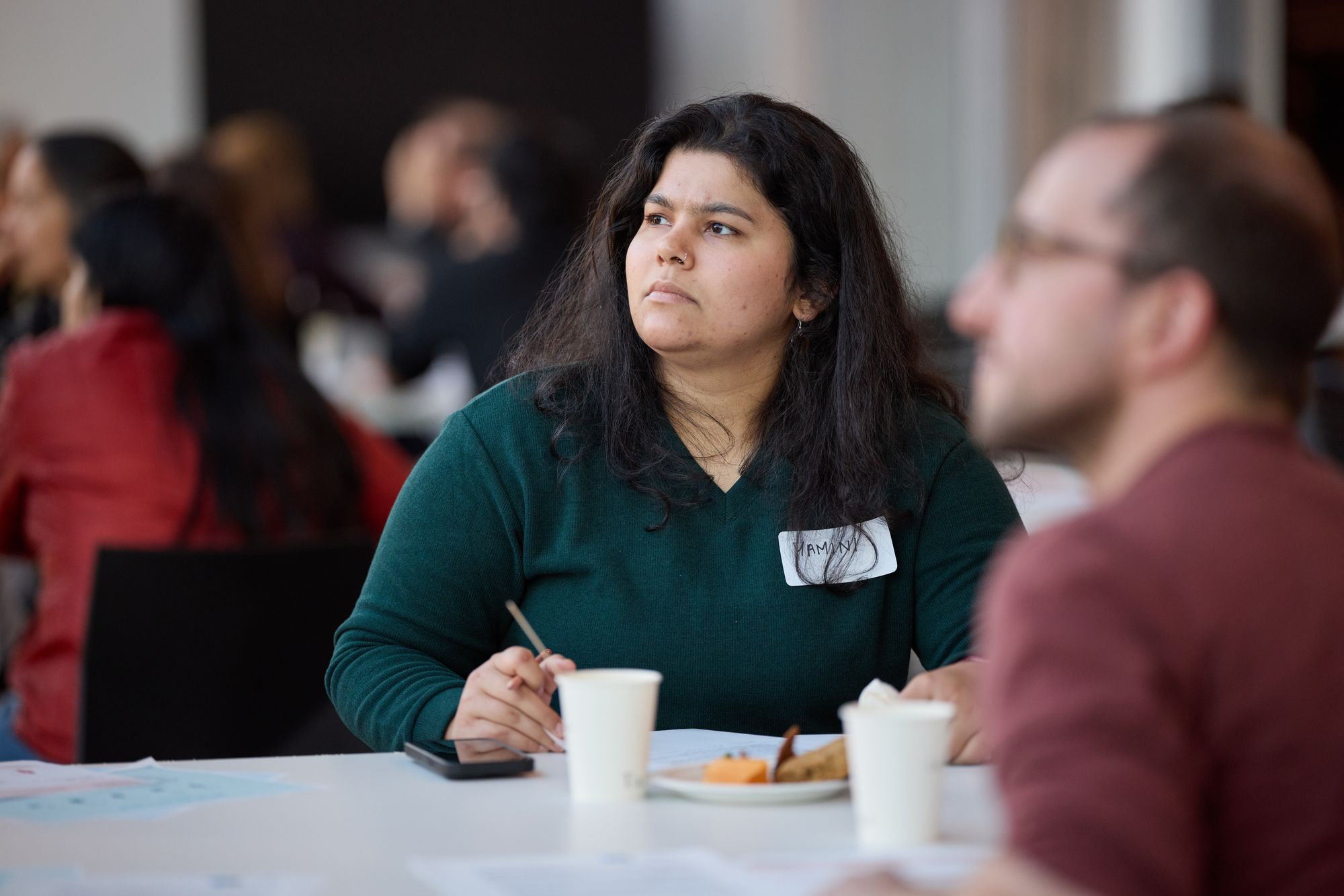 A workshop attendee listens carefully, pencil in hand.